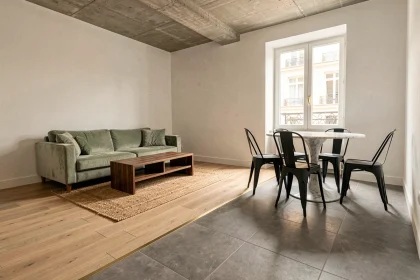 Salon et salle à manger ouverts avec transition parquet chêne et carrelage gris dans un appartement parisien moderne
